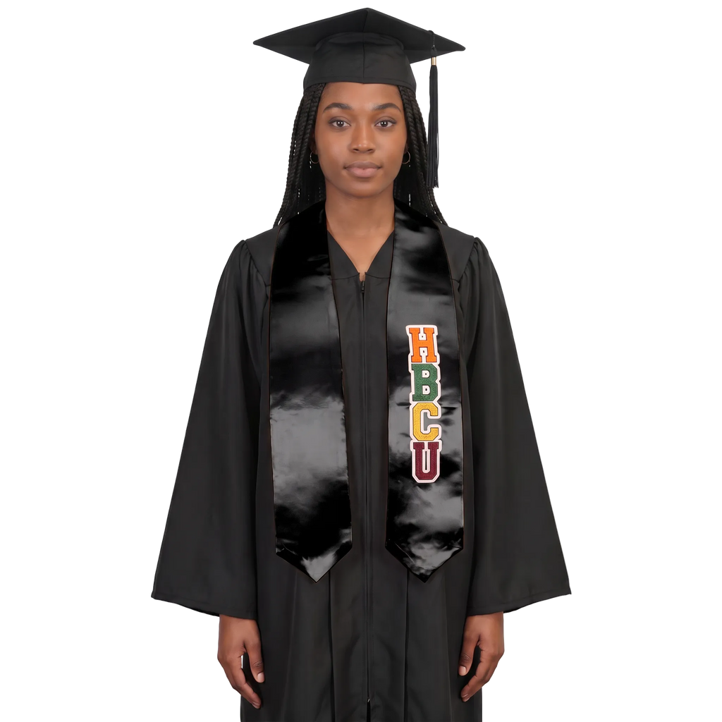 Model wearing a black HBCU graduation stole with multicolored vertical lettering and pointed ends over a black cap and gown.
