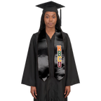 Model wearing a black HBCU graduation stole with multicolored vertical lettering and pointed ends over a black cap and gown.
