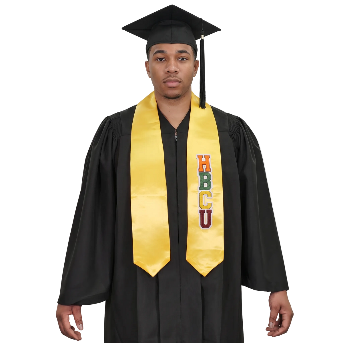 Model wearing a gold HBCU graduation stole with multicolored vertical lettering and pointed ends over a black cap and gown.
